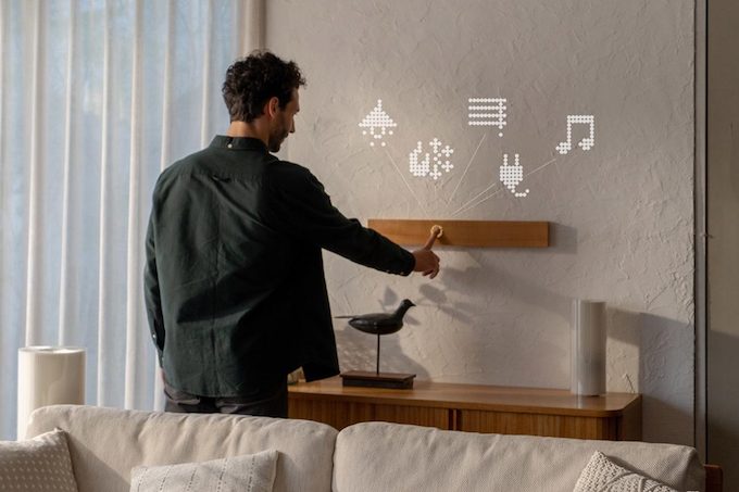 Man interacting with a mui Board Gen2 displaying smart home controls.