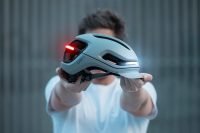 Person holding a AURA by UNIT 1 smart cycling helmet