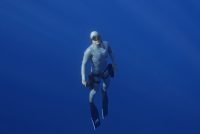 Diver in a wetsuit ascending in blue water with the LEFEET P1 scooter
