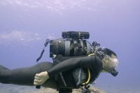 Scuba diver gliding over a coral reef with the LEFEET P1 scooter.