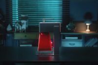 Longer Nano laser engraver glowing red in a dimly lit room