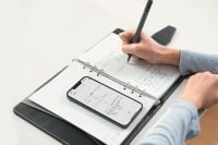 Person writing in a smart notebook with SyncPen 4