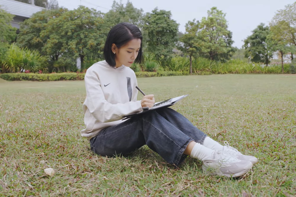 Woman outdoors, writing in a smart notebook with SyncPen 4