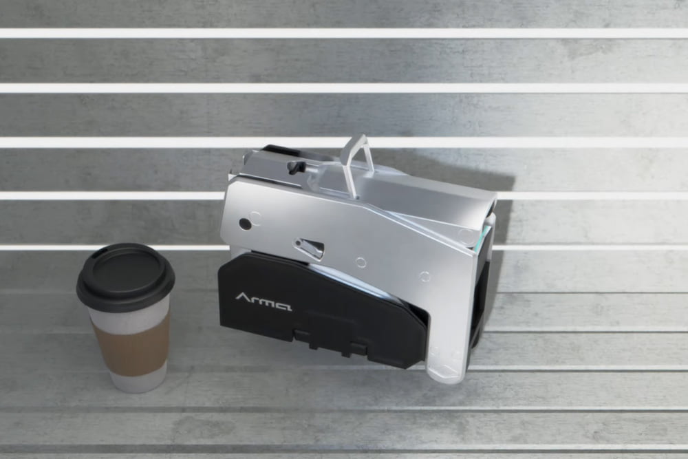 Folded Arma Scooter next to coffee cup on bench