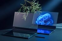 Lenovo ThinkBook Transparent with a blue wallpaper, reflecting on a dark surface
