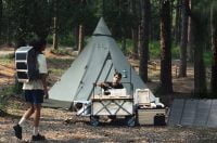 Two people camping in a forest and using Litheli W1 Pro