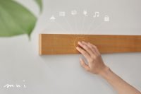 Hand touching mui Board Gen2 which projects smart home icons.