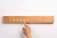 Close-up of a hand using the mui Board Gen2 to control smart home features.
