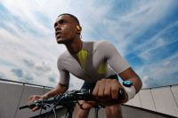 Cyclist wearing OWS Sports earphones with a focused expression
