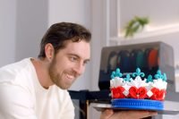 Individual admiring a colorful 3D printed crown by Phrozen Arco