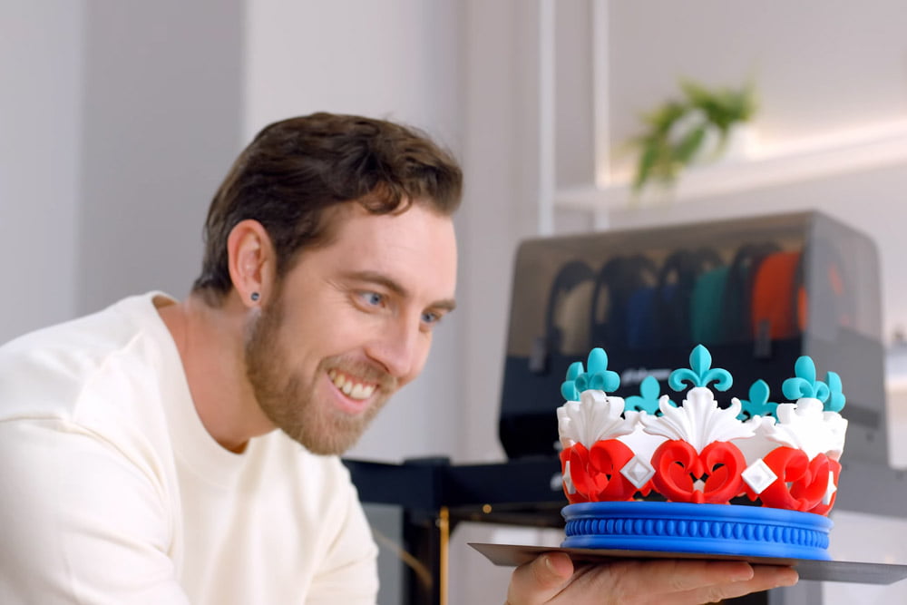 Individual admiring a colorful 3D printed crown by Phrozen Arco