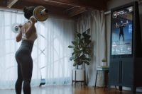 Woman performing barbell exercise with Tempo Studio guidance