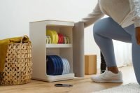 Close-up of a weight plate shelf beside a woman bending