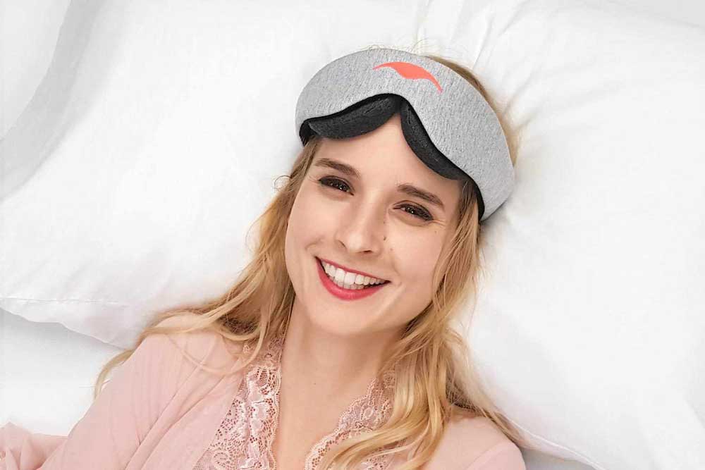 woman wearing Manta Sleep Mask on bed