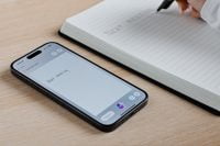 Writing 'Next meeting' in notebook beside smartphone with XNote