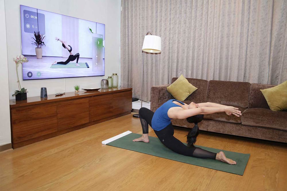YogiFi Smart Mat user practicing yoga with virtual class on TV
